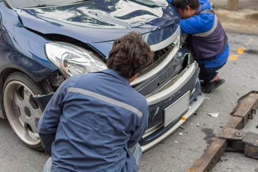 Car crash from car accident on the road in a city between saloon versus pickup wait insurance.