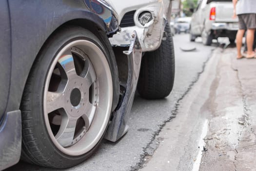 Car crash from car accident on the road in a city between saloon versus pickup wait insurance.