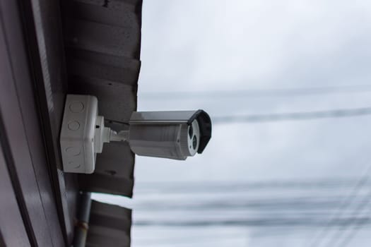 Security camera (CCTV) for safety on blue sky and city background
