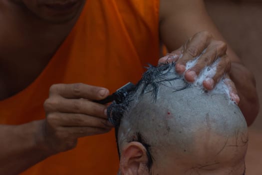 Thai monk hair shave a man for ordination ceremony in buddhist in Thailand
