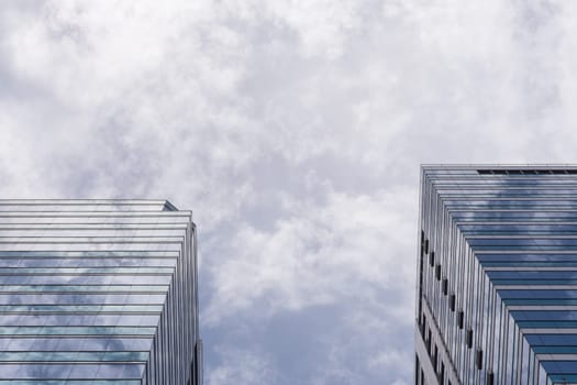 Big glass office building with blue sky and white cloud