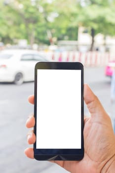 Person hand holding smartphone or mobile phone with white screen using on road