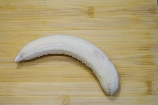 ripe fresh peeled yellow bananas skin on wooden board background fruits healthy snack vitamin eat immune colorful organic . High quality photo