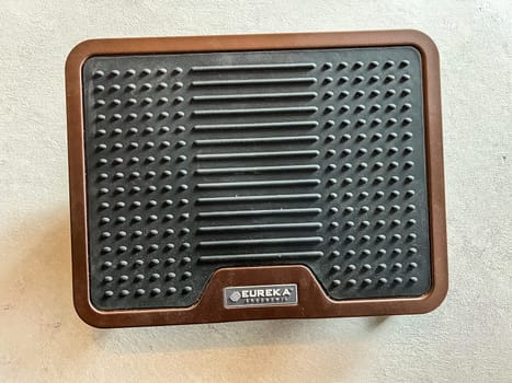 Castle Rock, Colorado, USA-April 25, 2023-A close-up view of an adjustable metal foot rest with a brown finish and a rubberized grip The design features a locking mechanism for stability and foldable legs for easy storage Ideal for ergonomic support and comfort in home or office settings
