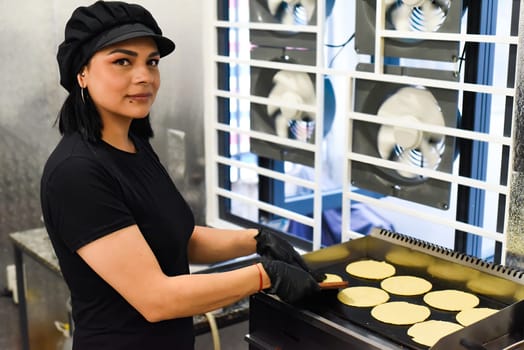 Mexican woman making tacos in a kitchen of a mexican cafe