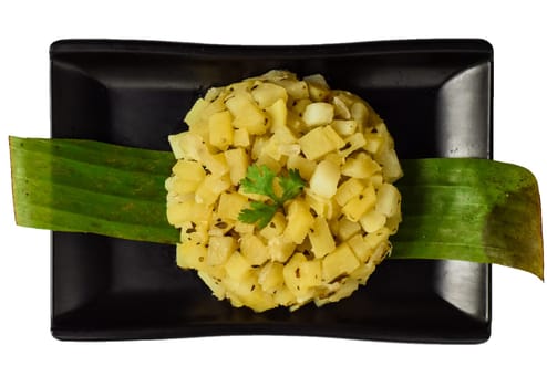 Mexican vegetarian boiled potato with oregano on black plate isolated on white background top view
