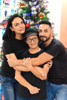 Mexican family standing together against christmas tree