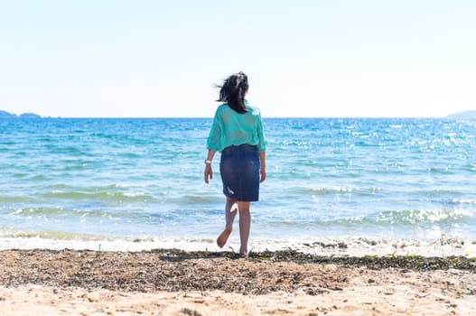 Office worker running to the sea after work. freedom concept