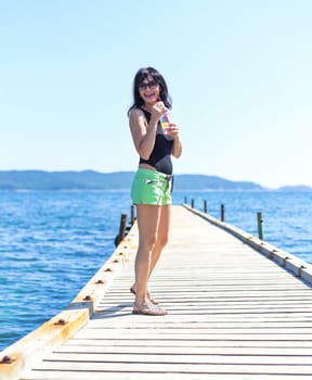 45 years old Russian woman drinking lemonad and standing on a pier