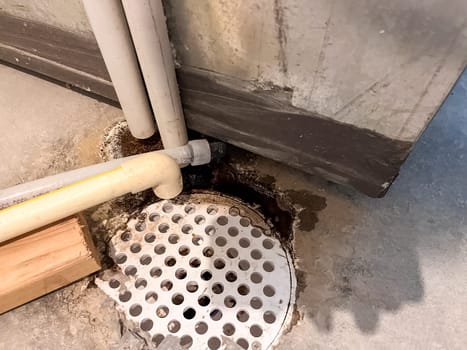 Castle Rock, Colorado, USA-June 11, 2023-A close-up view of a basement floor drain with visible water leakage around the surrounding pipes The area shows signs of moisture buildup and potential plumbing issues Pipes leading to the drain appear to have minor corrosion and residue This image highlights common basement drainage problems and the importance of maintenance