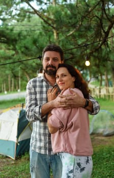 Young married couple feel happy and smile, standing in the forest in the evening