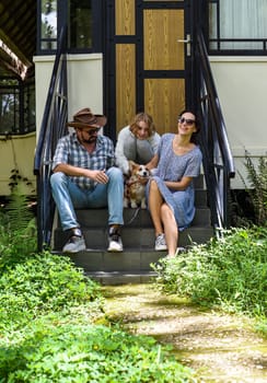 Family members father, mother and daughter sit on the porch of a their house