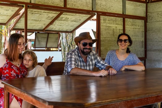 Family members father, mother and two daughters sit in alcove in park
