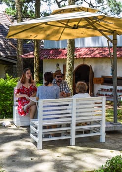 Family members father, mother and two daughters sit in alcove in park