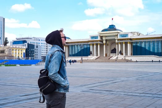Young tourist man travelling in Ulaanbaatar of Mongolia. sukhbaatar square