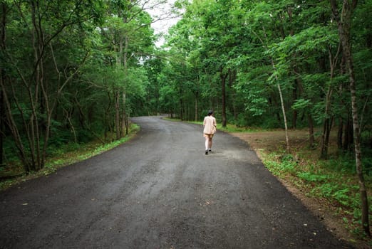 Woman traveler far away walking in the forest