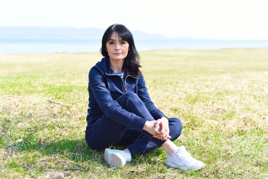 45 y.o. Russian woman sitting and enjoying nature at the beach of Japanese sea.