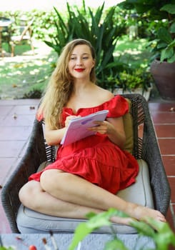 Beautiful blonde woman artist and illustrator thinking about idea of a drawing, sitting on a couch