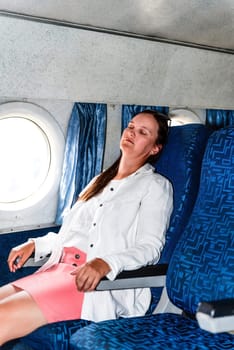 36 years old woman passenger enjoying during a flight in the airplane cabin