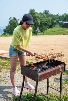 50 years old woman cooking bbq pork outdoors50 years old woman cooking bbq pork outdoors
