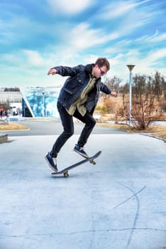 Young man riding a skateboard making tricks and jumps