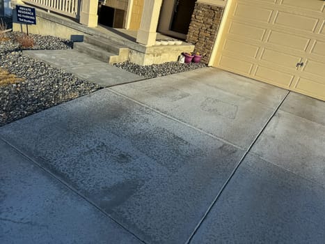 Castle Rock, Colorado, USA-July 22, 2023-A concrete sidewalk leading to a set of steps at the entrance of a home The surface shows weathering and stains from exposure to the elements Surrounding gravel landscaping adds contrast to the structure