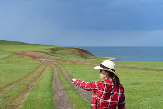 Young girl in red shirt pointing her finger to the path of Cape Kharantsy
