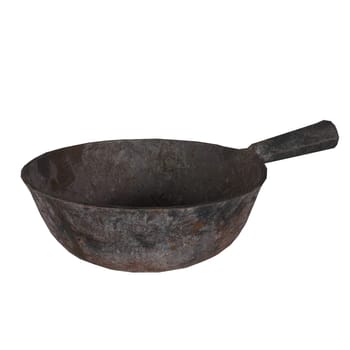 A worn-out iron frying pan rests on a plain white surface, showcasing its rustic charm.