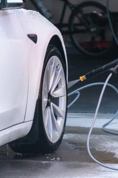 Denver, Colorado, USA-September 1, 2023-Efficiently cleaning an electric car in the comfort of a suburban driveway, combining eco-consciousness with practicality.