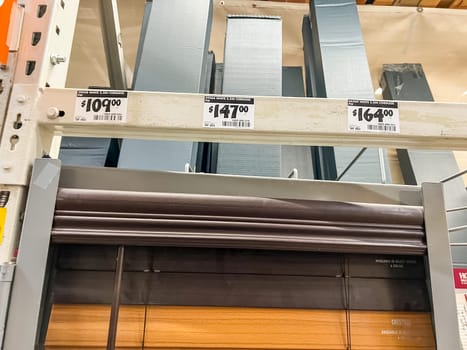 Castle Rock, Colorado, USA-January 21, 2023-A store display featuring metal corner guards in various sizes and prices along with a roll-up window shade The metal corner guards are available in different finishes with price tags showing 109 147 and 164 dollars The roll-up shade below has a wood-like finish with a dark brown valance