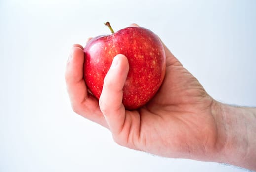 Red apple in male's hand isolated on white