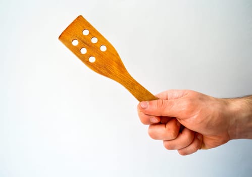 Man's hand with wooden spatula isolated on white