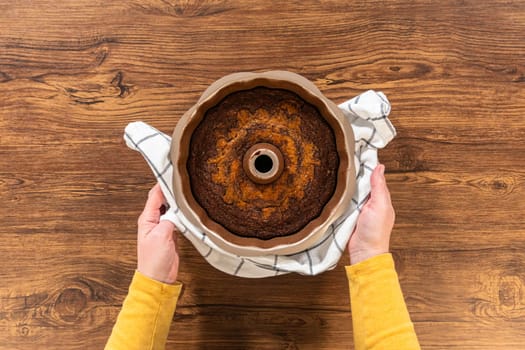 Flat lay. The gingerbread bundt cake cools gracefully on a wire rack, awaiting its sweet caramel frosting.