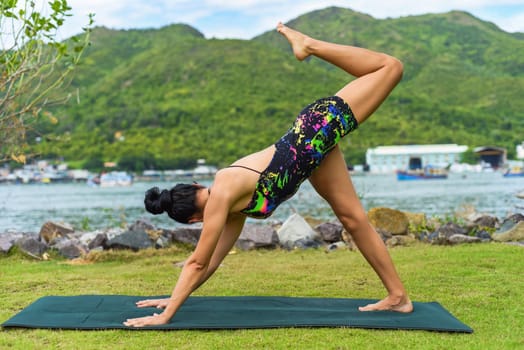 three legged dog pose or tri pada adho mukha svanasana yoga with ukrainian woman making it outdoors