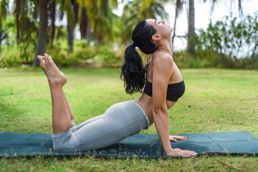 king cobra pose or rajakapotasana yoga with ukrainian woman making it outdoors