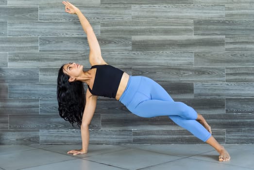 side plank pose or vasisthasana yoga with ukrainian woman making it indoors