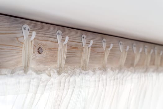rustic wooden curtain with tulle hooks close up