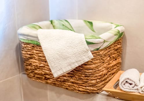 wooden wicker basket with towels on wooden shelf for bathroom