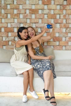 Ukrainian woman (brunette) and Russian woman (blonde) portrait together with braids posing and taking a selfie