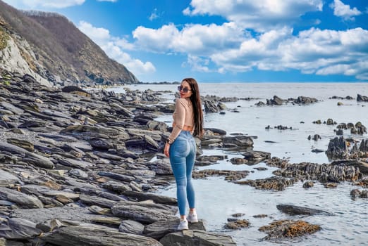 Young russian brunette woman in beige blouse standing near Japanese sea