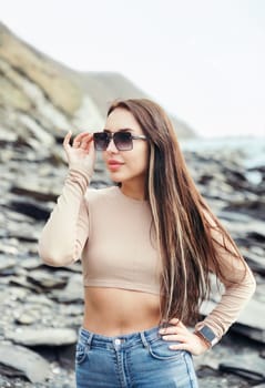 Young russian brunette woman in beige blouse standing near Japanese sea