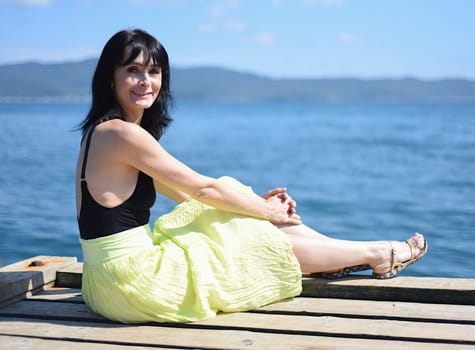 45 years old Russian woman smiling and looking at front against Japanese sea