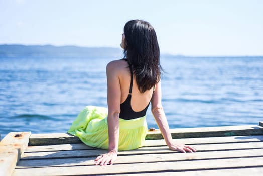 45 years old Russian woman smiling and looking at front against Japanese sea