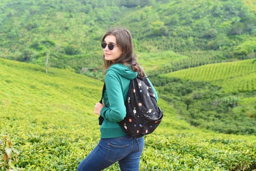 Brunette woman traveller with backpack in tea hill in Da Lat Vietnam