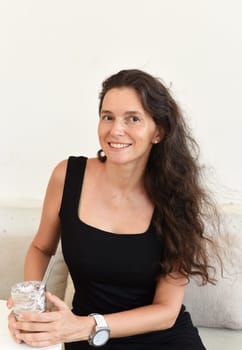 Successful 40 year old sitting in a cafe with glass of ice coffee and looking left