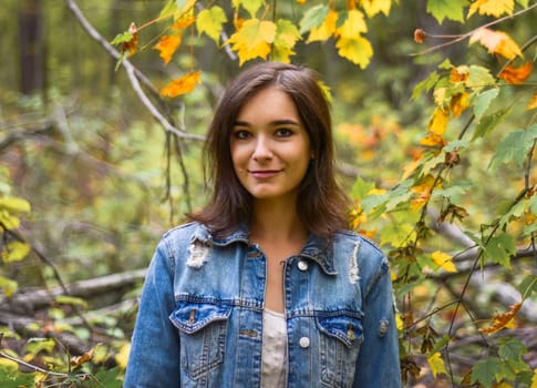 Portrait of russian young girl looking in camera against forest
