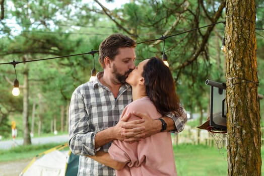 Young married couple kissing and standing in the forest in the evening