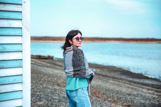 49 year old Russian woman covered herself with a scarf on an early spring  day against japanese sea