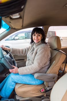 Young attractive 49 years old woman in jacket driving the car