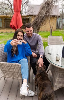 Young married couple making a selfie and laughing on the backyard of their house